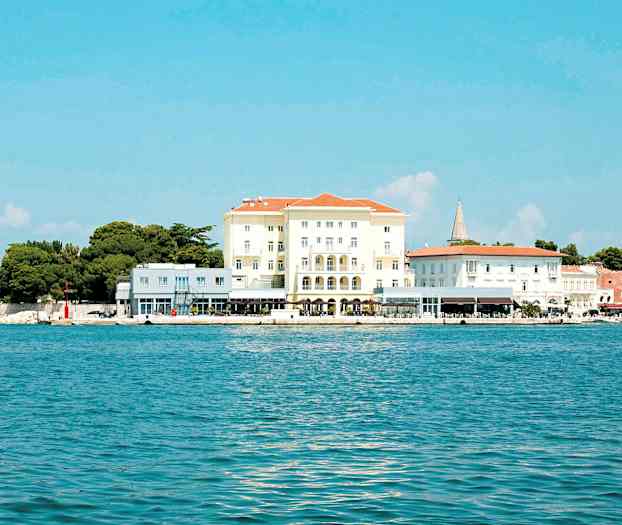 Billede af en bygning ved kysten med blåt hav og klar himmel. (AI-genereret tekst)