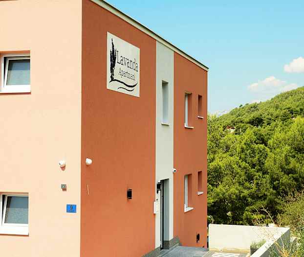 Illustration af en bygning med skiltet 'Lavanda Apartmani', omgivet af grøn vegetation. (AI-genereret tekst)