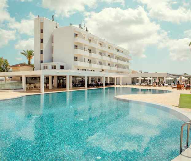 Hotel med en stor pool og liggestole. (AI-genereret tekst)