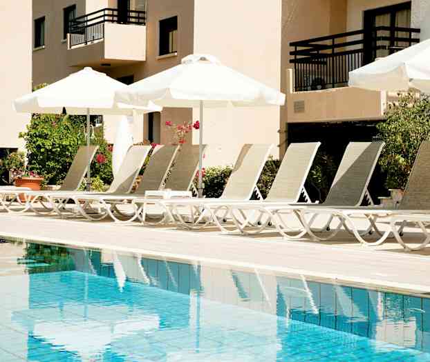 Liggestole ved en pool med parasoller. (AI-genereret tekst)