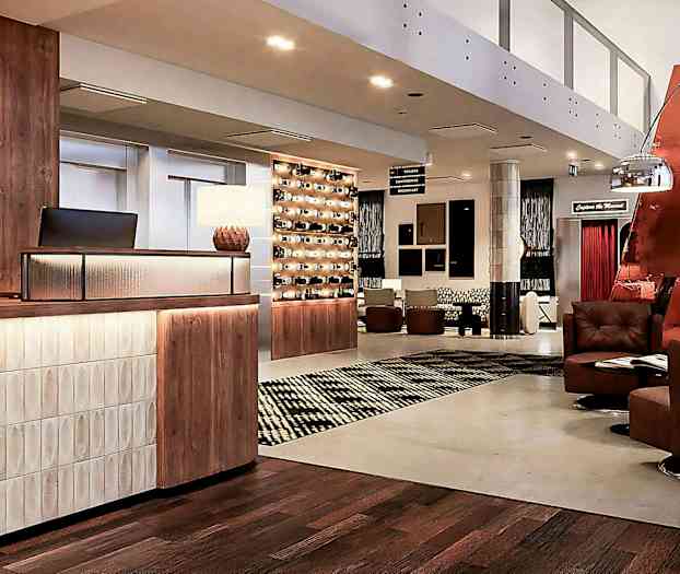 Hotellets lobby med receptionsdisk, siddepladser og dekorativ belysning. (AI-genereret tekst)