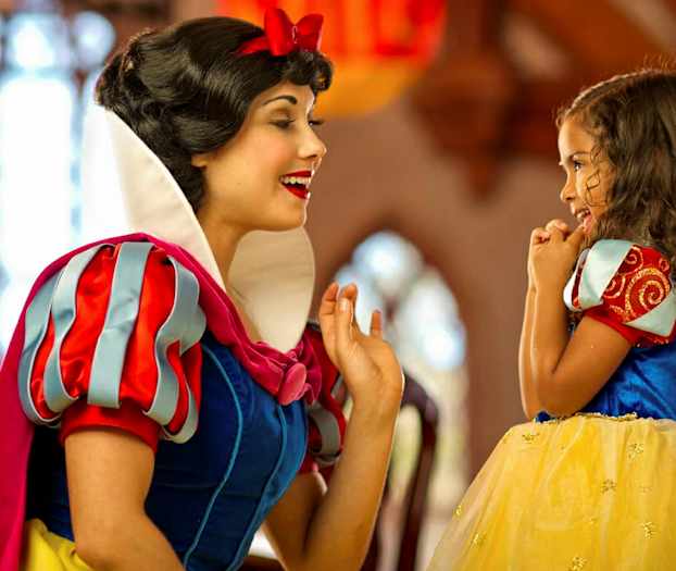 To personer er klædt som Snehvide og en prinsesse i et farverigt miljø. (AI-genereret tekst)