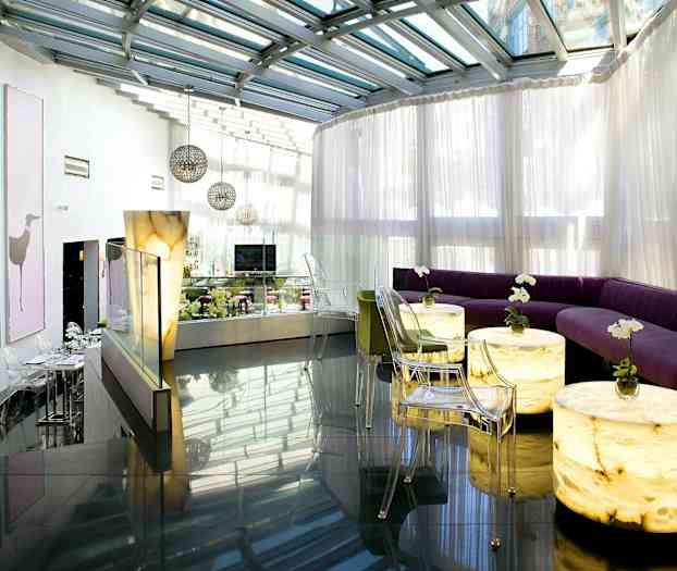 Moderne lounge med glastag og lyse siddepladser. (AI-genereret tekst)