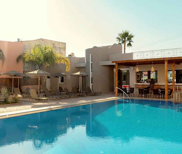 En udendørs pool ved en bygning med liggestole og parasoller samt en bar. (AI-genereret tekst)