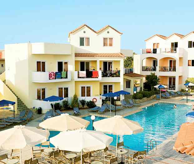 Et hotelområde med en pool og omkringliggende bygninger med altaner. (AI-genereret tekst)