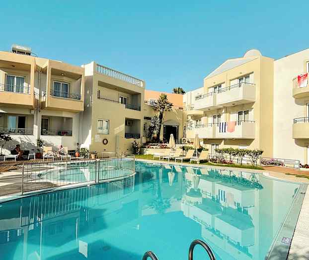 Udvendig af en bygning med altaner og en pool i forgrunden. (AI-genereret tekst)