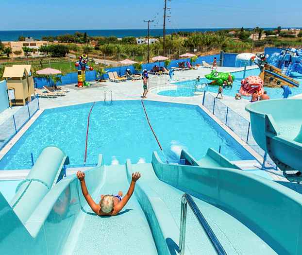 En vandpark med pools, vandrutsjebaner og legeområder, med udsigt over landskabet og havet. (AI-genereret tekst)