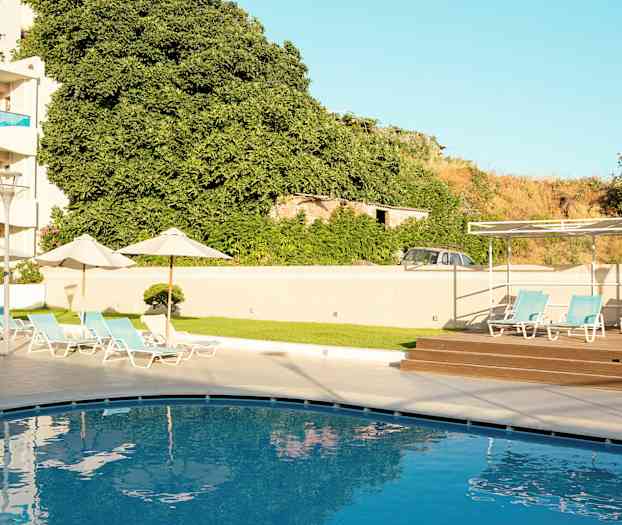 En swimmingpool med liggestole i en hotelmiljø. (AI-genereret tekst)