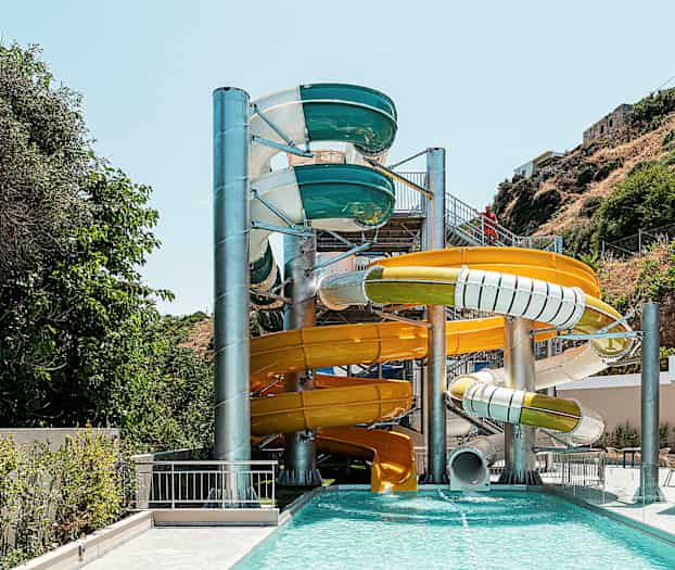 Flere farverige vandrutsjebaner ved en udendørs pool. (AI-genereret tekst)