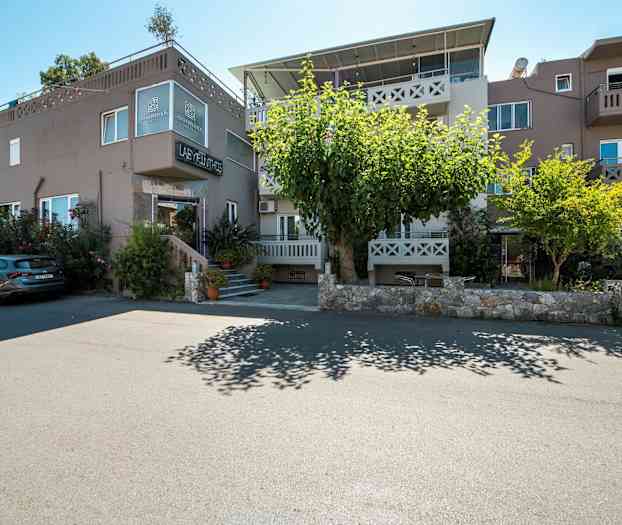 Udvendig af bygning med boliger og parkerede biler foran. (AI-genereret tekst)