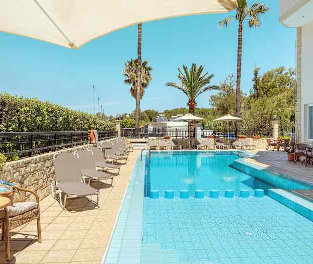 Udendørsområde med pool, liggestole og parasoller. (AI-genereret tekst)