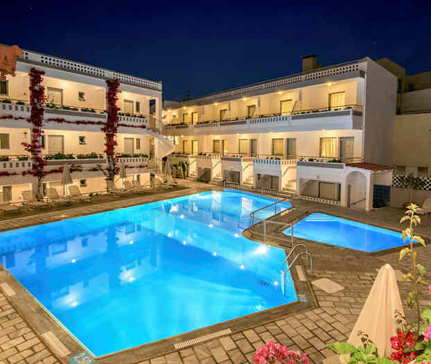 Hotel med tre etager, pool i forgrunden og blomstrende planter. (AI-genereret tekst)