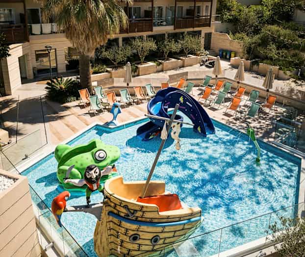 En pool med børnevenlige figurer og en rutsjebane, omgivet af solsenge og en palme. (AI-genereret tekst)