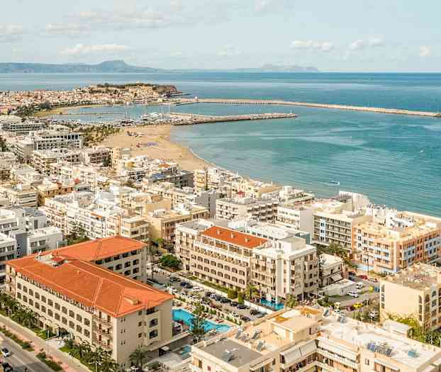 Luftfoto af en by ved kysten med sandstrand og bådhavne. (AI-genereret tekst)