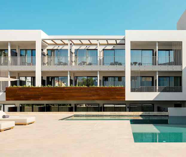 Moderne hotel med pool og liggestole. (AI-genereret tekst)