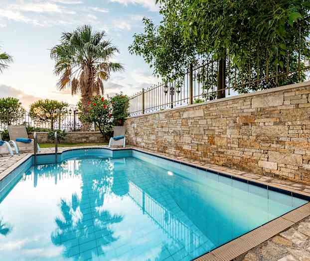 Udendørs pool med liggestole og palmer i baggrunden. (AI-genereret tekst)