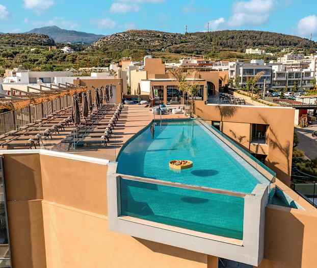 En udendørs swimmingpool på en tagterrasse med liggestole ved siden af. (AI-genereret tekst)