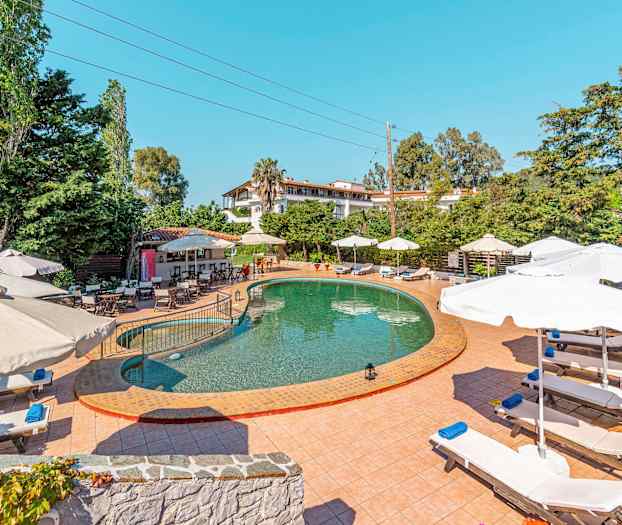 Udendørs pool med liggestole og parasoller. (AI-genereret tekst)