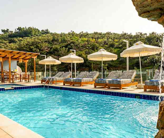 Udendørs pool med liggestole og parasoller omgivet af grønne omgivelser. (AI-genereret tekst)