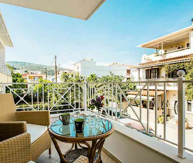 Altan med udsigt over boligbygninger, træer og bjerge. (AI-genereret tekst)