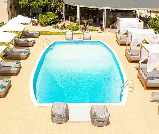 Udendørs pool omgivet af liggestole og baldakiner. (AI-genereret tekst)