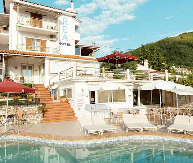 En hotelbygning med flere niveauer og en pool i forgrunden. (AI-genereret tekst)