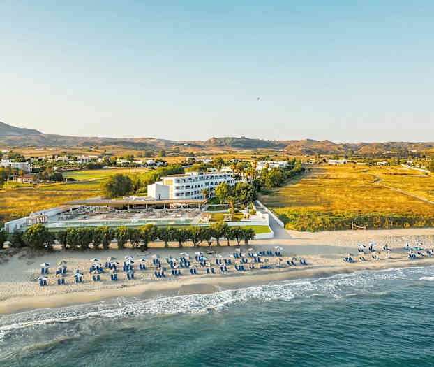 Strand og hotel med omkringliggende landskab. (AI-genereret tekst)