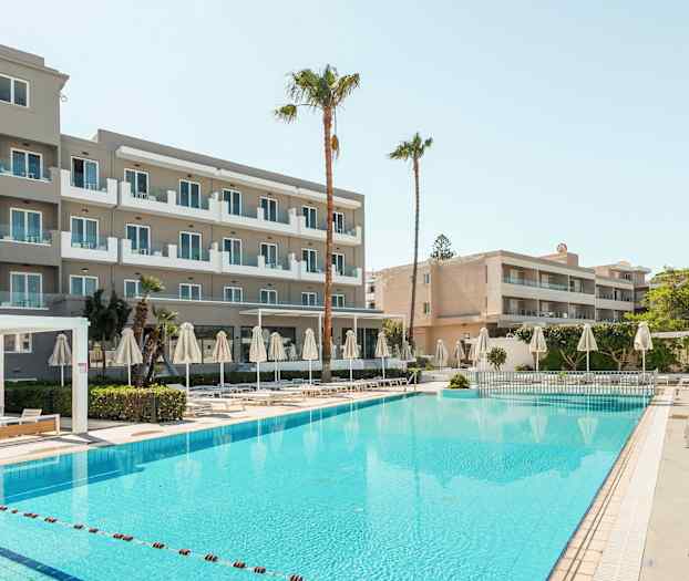 Billede af et hotel med altaner, en pool samt liggestole og parasoller. (AI-genereret tekst)