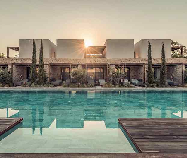 Billede af en moderne villa med en pool foran, omgivet af vegetation og træer, med solens stråler synlige bag bygningen. (AI-genereret tekst)