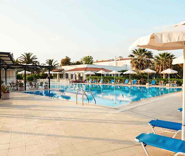 Billede af en pool med liggestole og parasoller rundt omkring. (AI-genereret tekst)