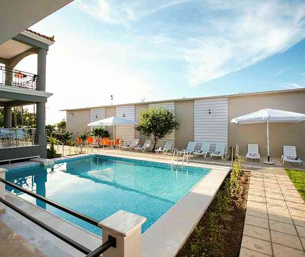 Udendørs pool med liggestole og parasoller på terrassen. (AI-genereret tekst)