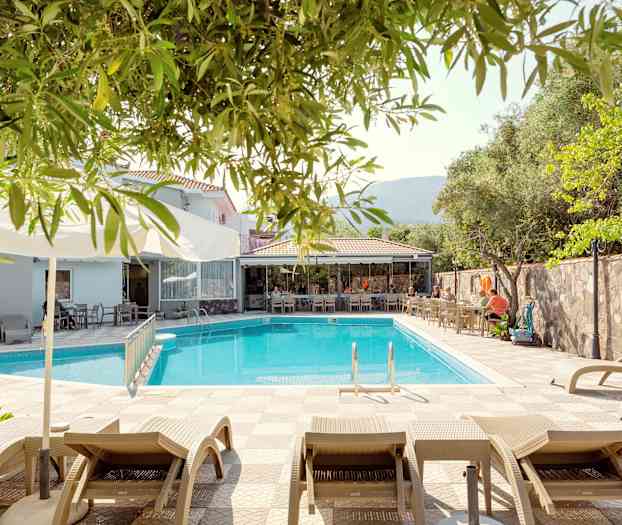 Liggestole ved en pool tæt på en udendørs servering. (AI-genereret tekst)