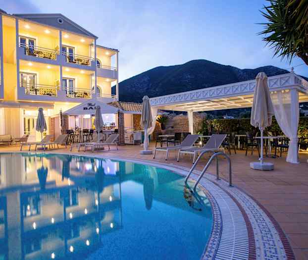 Hotellets facade med pool og liggestole i forgrunden. (AI-genereret tekst)