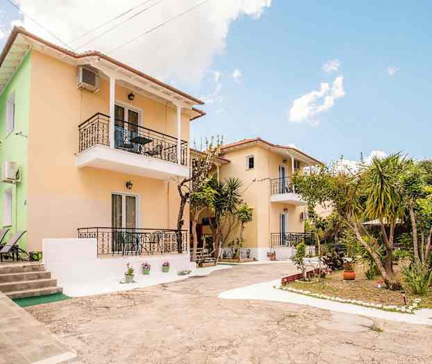 To små huse med altaner omgivet af planter og træer. (AI-genereret tekst)