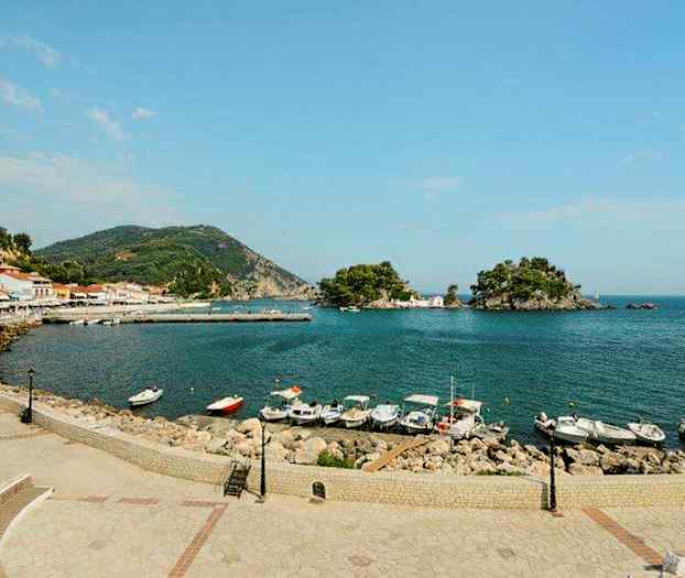 Udsigt over en havn med flere både, omgivet af bjerge og små øer. (AI-genereret tekst)