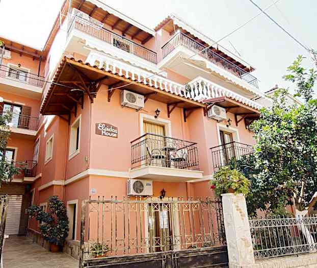 En bygning malet i rødt med flere altaner og gitre foran. (AI-genereret tekst)