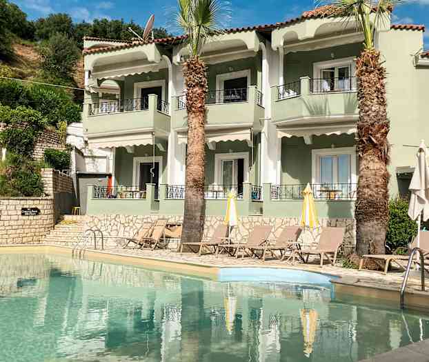 Lejlighedskompleks med pool og liggestole foran. (AI-genereret tekst)