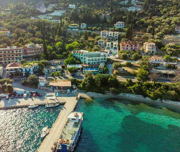 Luftfoto af en kystby med huse og grønne områder ved vandet. (AI-genereret tekst)