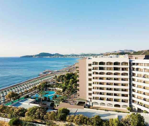 Udsigt over hotelbygning nær sandstrand og hav med solsenge og parasoller. (AI-genereret tekst)