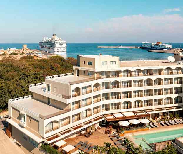 Hotelbygning tæt ved havn og hav. (AI-genereret tekst)