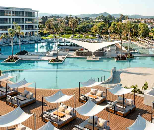 Et moderne feriested med swimmingpool, liggestole og grønne områder. (AI-genereret tekst)