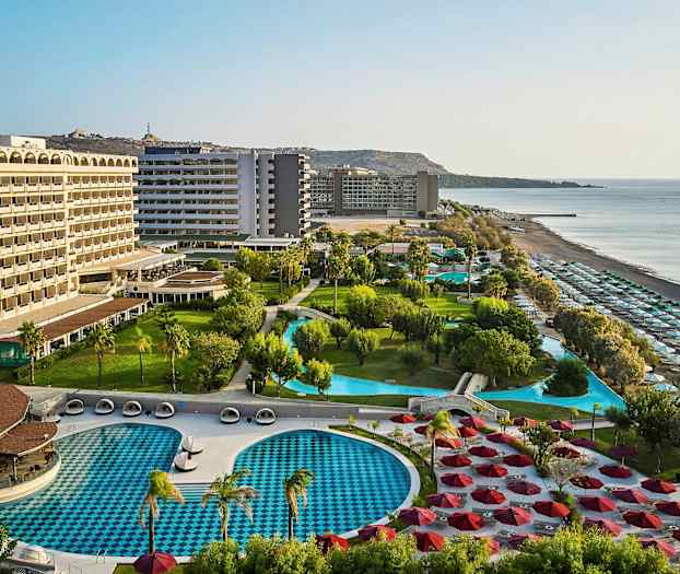 Hotelområde med pools, grønne områder og strand. (AI-genereret tekst)