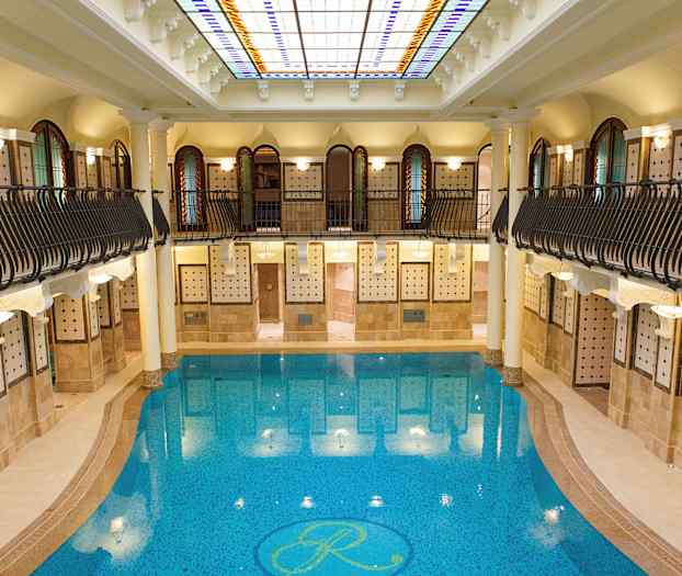 Indendørs swimmingpool med omgivende arkitektur. (AI-genereret tekst)