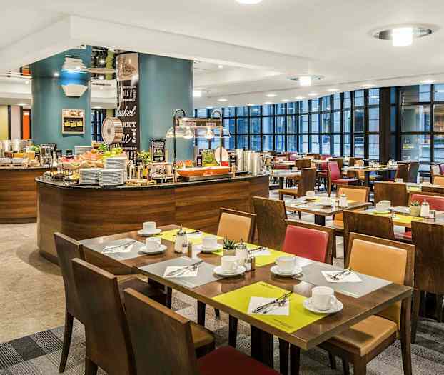 En restaurantinteriør med dækkede borde og en buffestation. (AI-genereret tekst)