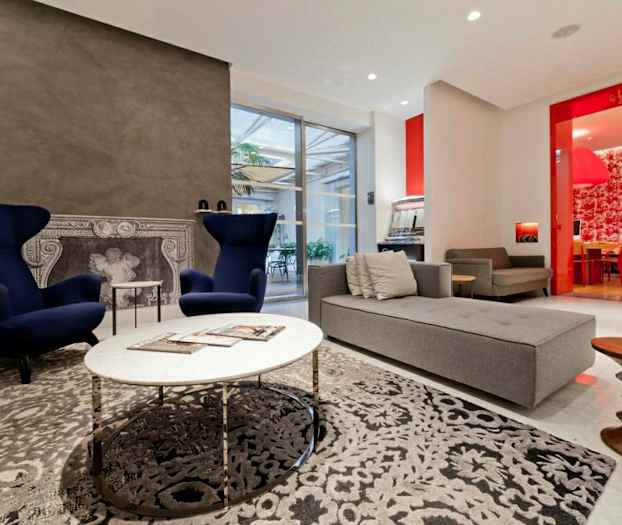 Moderne indrettet stue med lænestole, sofa og dekorativ pejs. (AI-genereret tekst)