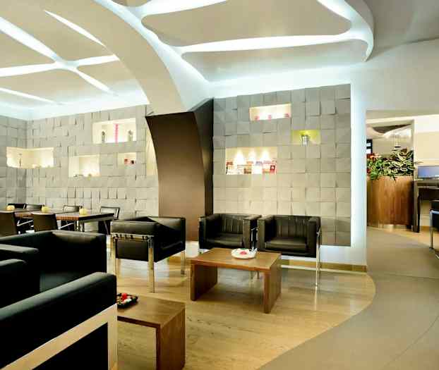 Moderne café med siddepladser, dekoreret med mønstrede vægge og elegant interiør. (AI-genereret tekst)