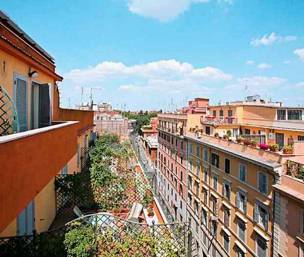 Udsigt over boliger fra en altan, med himmel og skyer i baggrunden. (AI-genereret tekst)