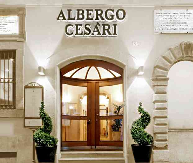 Hotelindgang med velplejede planter og dekorativ arkitektur. (AI-genereret tekst)