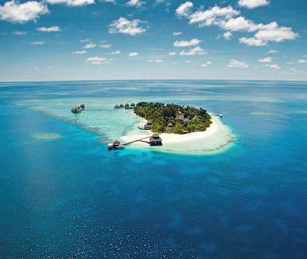 En lille tropisk ø omgivet af turkis vand og hvide sandstrande. (AI-genereret tekst)