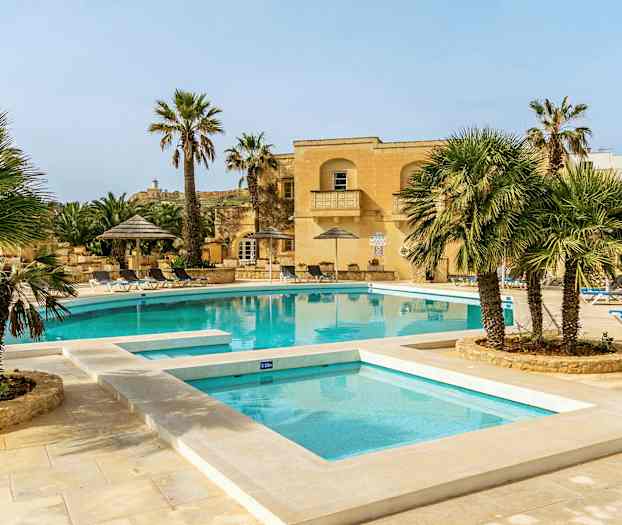 En udendørs pool omgivet af liggestole, parasoller og palmer. (AI-genereret tekst)